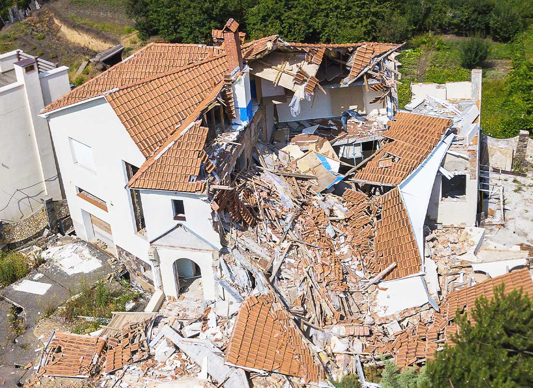 Earthquake Insurance - Aerial View of a Destroyed Luxury Home after an Earthquake on a Sunny Day